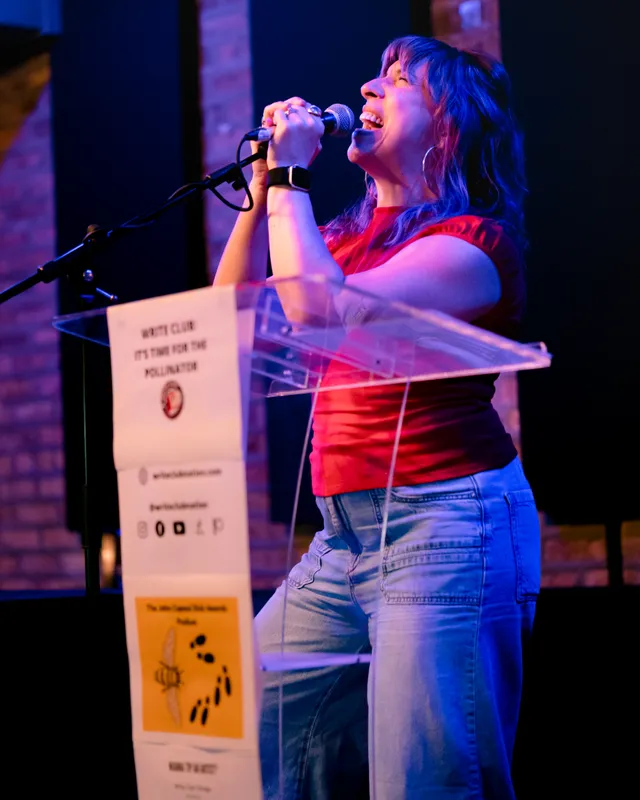 A combatant in a red top, head back, singing into the microphone